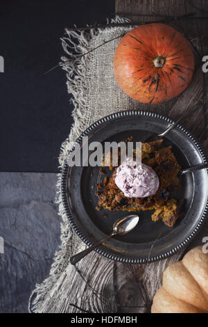 Pumpkin dump cake with ice cream on the metal plate on the stone table  vertical Stock Photo