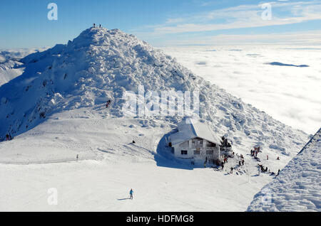 View of the top of mountain Chopok and tourists on a sunny winter day, Low Tatras, Slovakia. Stock Photo