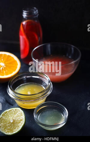 Citrus juice in the different glass bowl on the dark stone background Stock Photo