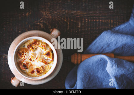 Ceramic pot with onion soup on the wooden table  top view Stock Photo