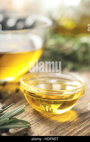 Olive oil  in the glass bowl on wooden table  vertical Stock Photo