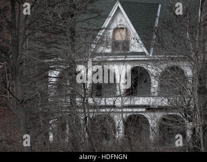 An abandoned house tagged with graffiti sits in the woods adjacent the Thames River in Southwestern Ontario Canada. Stock Photo