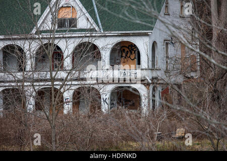 An abandoned house tagged with graffiti sits in the woods adjacent the Thames River in Southwestern Ontario Canada. Stock Photo