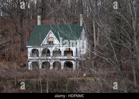 An abandoned house tagged with graffiti sits in the woods adjacent the Thames River in Southwestern Ontario Canada. Stock Photo