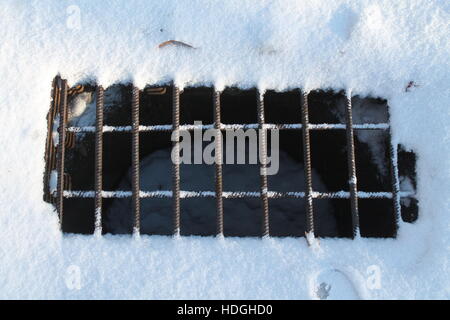 solid metal grille covered stock in to underground communication in winter day Stock Photo