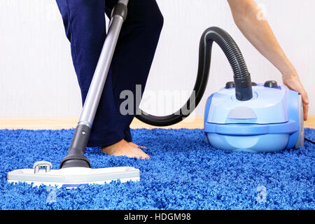 Powelful vacuum cleaner in action-a men cleaner a carpet ...