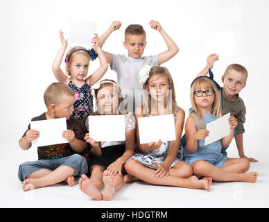 a group of children holding white card Stock Photo