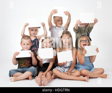 a group of children holding white card Stock Photo