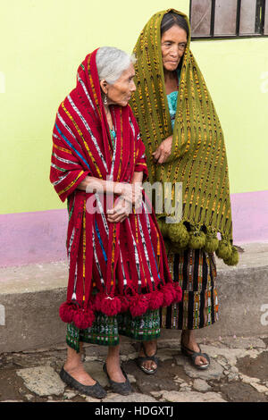 Two old women, a mother and daughter in traditional dress with their mantillas over their heads, watch an approaching Catholic religious procession in Stock Photo