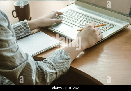 Young woman's hands working at a laptop Stock Photo