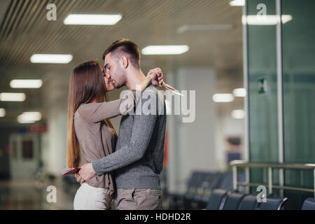 Side view of romantic young couple kissing at airport Stock Photo