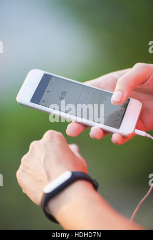 Cropped image of woman using pedometer and mobile phone Stock Photo