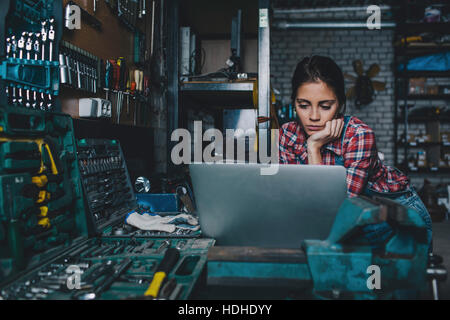 Female mechanic using laptop at workshop Stock Photo