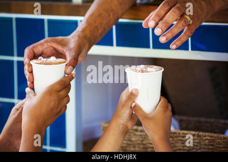 Close up of human hands holding paper cups. Stock Photo