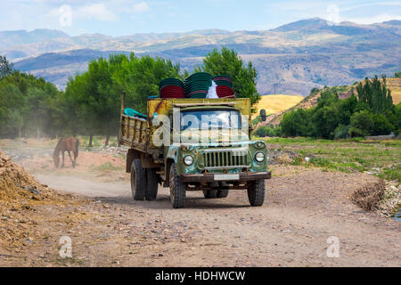 Old loaded soviet truck driving on local road in Kazakh steppe Stock Photo