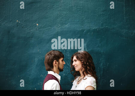 Loving couple looking at each other against blue shabby wall, copy space Stock Photo