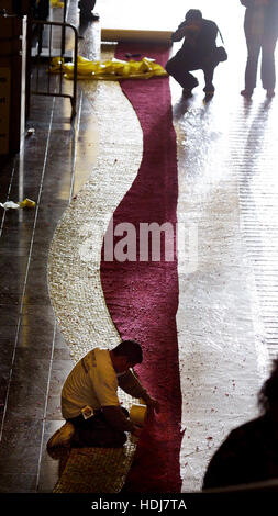 A worker lays a red carpet at the entrance to the Kodak Theater, the site of the Academy Awards,  in Los Angeles, California  on  February 26, 2004.  Photo by Francis Specker Stock Photo