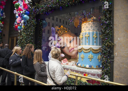 People check out the Christmas holiday window displays at Saks Fifth Avenue in Manhattan, NYC. Stock Photo