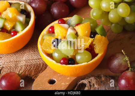 Oranges stuffed with fresh fruit salad close-up on the table. horizontal view from above Stock Photo