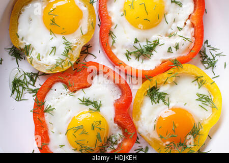 fried eggs with yellow and red peppers macro. horizontal view from above Stock Photo