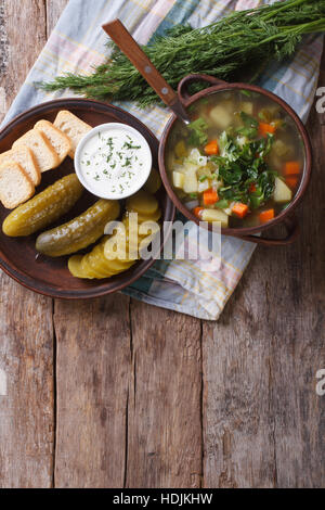 soup with sour cucumber and vegetables on the table. vertical top view Stock Photo