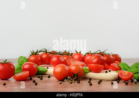 Mini tomaotes on the wooden table with bright background. Stock Photo