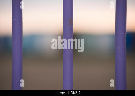 Close up of three metal bars (railings) painted purple, out of focus background. Stock Photo