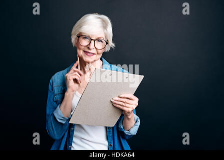Cheerful elderly woman holdign folder Stock Photo