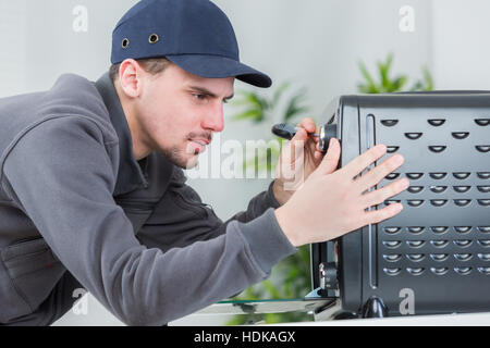 Young man repairing household appliance Stock Photo