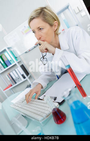 a young thoughtful female chemist working in the lab Stock Photo