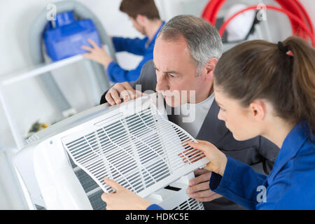 Students working on air conditioning unit Stock Photo