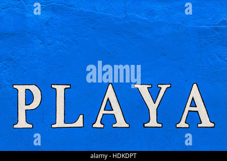 White 'playa' sign painted on a blue wall. Horizontal image. Stock Photo