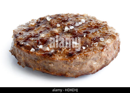 Single grilled hamburger patty with salt isolated on white. Stock Photo