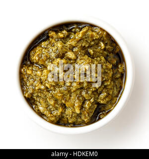 Sicilian style basil pesto in ceramic bowl isolated on white from above. Stock Photo