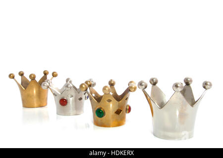 Silver and golden crowns in a row isolated over white Stock Photo