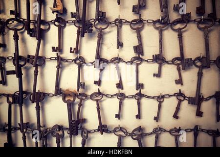 Group of old keys hanging on a wall. Stock Photo