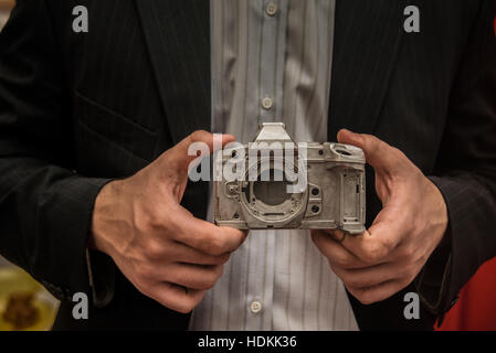 Businessman taking aluminum metal body photo camera OLIMPUS with vintage camera. Close up image photo. metal part detail or piece. extra light  housin Stock Photo