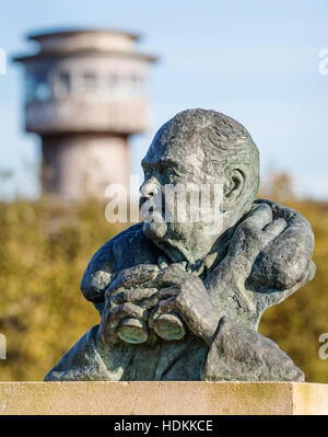 Bronze sculpture of Sir Peter Scott birdwatching with viewing tower at Slimbridge Wildlife and Wetlands Centre Gloucestershire Stock Photo