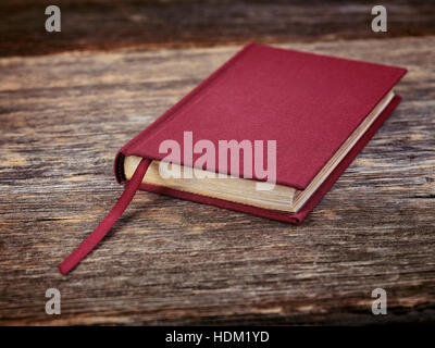 Small red hardcover book on wooden table background Stock Photo