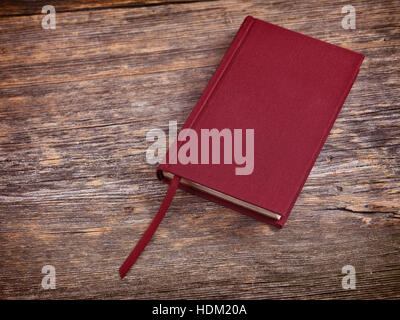 Red hardcover book on wooden table background Stock Photo