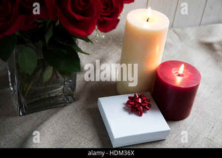 Gift box and two candles with roses Stock Photo