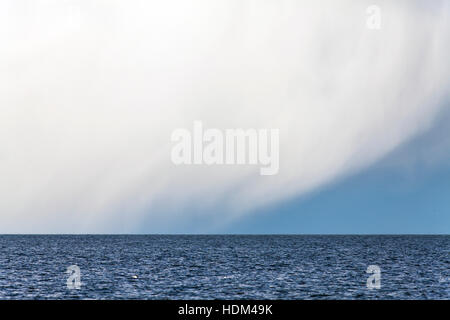 Shower at sea. Rain, hail and snow. Water, waves and rough weather. Stock Photo