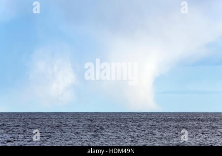 Shower at sea. Rain, hail and snow. Water, waves and unstable weather. Stock Photo