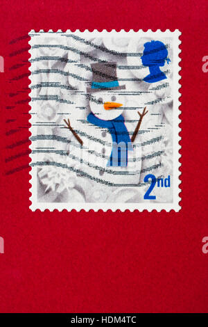 2nd class postage stamp with snowman stuck on red envelope Stock Photo