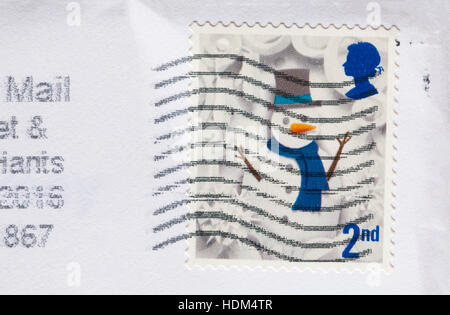 2nd class postage stamp with snowman stuck on white envelope Stock Photo