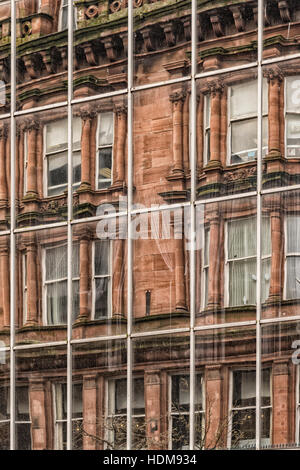 A modern office building in the city centre of Glasgow reflects the vintage red sandstone tenements that once dominated the city. Stock Photo