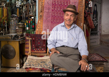 A vendor sits at the front of his handicrafts stall in the Isfahan Bazaar, Isfahan Province, Iran Stock Photo