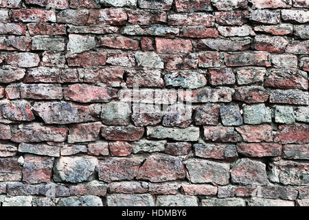 Stone wall closeup, horizontal stonewall pattern background, old aged weathered red and grey grunge limestone dolomite calcium carbonate hard sediment Stock Photo
