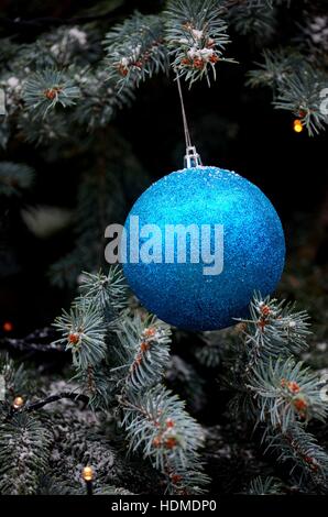 Glittering blue hanging ball decoration on Christmas tree Stock Photo