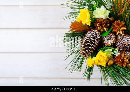 Christmas background with golden pine cones and yellow fabric roses. Christmas table centerpiece. . Christmas decoration with fir branches and pine co Stock Photo